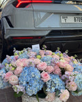 BLUE AND PINK FLOWERS BOUQUET IN BASKET WITH HYDRANGEA AND ROSES