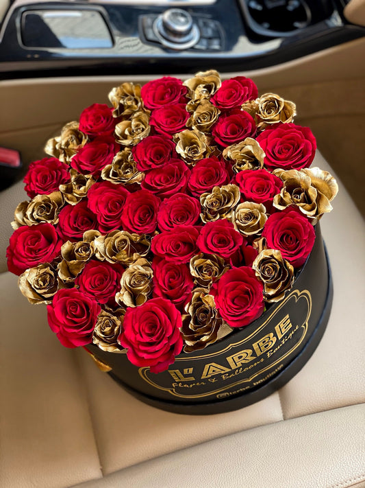 Box 30 cm with golden roses and red roses